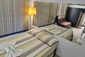 una habitación de hotel con dos camas y una silla en Apto203 a 100 mts do Shopping Carioca, Brt e Metrô, en Río de Janeiro