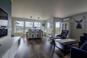 a living room with a table and a dining room at Exclusive fjordside villa with swimming pool, sauna, jacuzzi and boat hire in Sveio