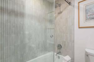 a bathroom with a shower and a tub and a toilet at The Charter at Beaver Creek E135 in Beaver Creek