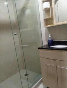 eine Glasdusche im Bad mit Waschbecken in der Unterkunft APART -Hotel 2 habitaciones compartidas con baños privado in Vila El Carmen