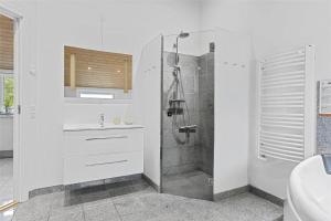 a white bathroom with a shower and a sink at 0195-Romo-Smafolksvej-65 in Kongsmark +15 photos