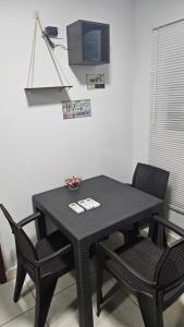 a black table with two chairs and a microwave at APART -Hotel habitaciones privadas in Vila El Carmen