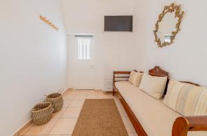 Una sala de estar con un sofá y un televisor. en Earthy House - 1, en Mesariá