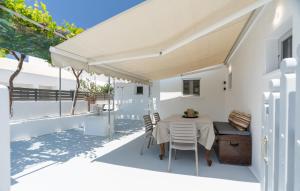 Un comedor blanco con una mesa y sillas. en Earthy House - 1, en Mesariá