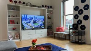 a living room with a television in a white entertainment center at Downtown Cleveland- Steps to Sports & Events condo in Cleveland +38 photos