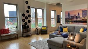 a living room with a couch and chairs and windows at Downtown Cleveland- Steps to Sports & Events condo in Cleveland