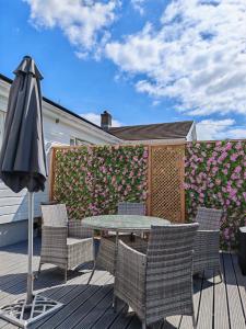a patio with a table and chairs and an umbrella at Pinecroft in Pembrokeshire +29 photos