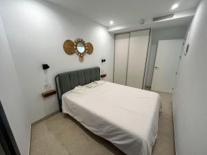 a bedroom with a white bed and a mirror at Luxury House in El Mirador Calaceite Torrox Costa, Hus 19 in Torrox Costa