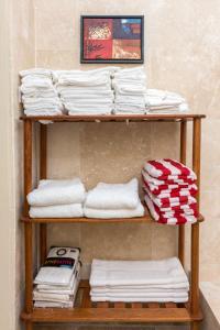 a stack of towels on a shelf in a room at Sandrati Villa in Port Elizabeth