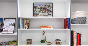a white book shelf filled with books at Cosy logement Hyper Centre-ville in Quimper