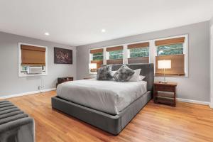 a bedroom with a bed and a couch and windows at Sojourn Beautiful Family Home with Beach Access & Backyard in Falls Church