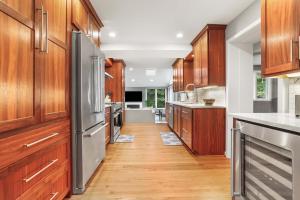 a kitchen with wooden cabinets and stainless steel appliances at Sojourn Beautiful Family Home with Beach Access & Backyard in Falls Church