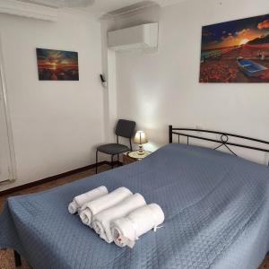 una camera da letto con un letto blu con asciugamani sopra di Beautiful and Remodeled Apartment 1A a Mytilini