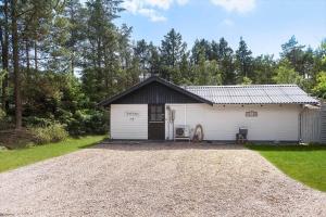a white garage with a gravel driveway at BV384-Blavand-Hedevej-47 in Blåvand