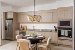 a kitchen with a table and chairs in a kitchen at Costa Elena at Naumi, Ocean Views & Beach Club in Sardinal