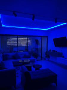 a blue room with a couch and a tv at Appartement marina hammamet in Hammamet +4 photos