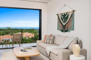 un salon avec un canapé et une grande fenêtre dans l'établissement Costa Elena at Naumi, Ocean Views & Beach Club, à Sardinal 20 autres photos