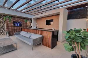 a patio with a couch and a bar with a tv at Studio Moderno no Ingá com Vista in Niterói