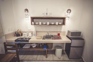 a small kitchen with a sink and a microwave at Aldea San Lam - Oasis Of Tulum in Tulum