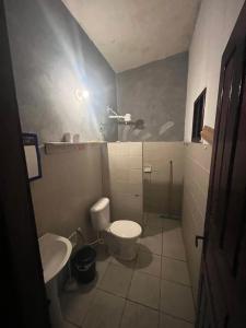 een kleine badkamer met toilet en wastafel bij Quarto Golfinhos - Masculino in Pipa