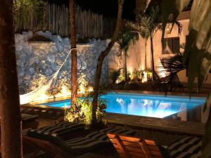 a swimming pool in a resort with palm trees at Aldea San Lam - Oasis Of Tulum in Tulum