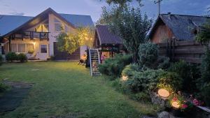 a woman sitting in a yard in front of a house at GONTA kottage - БАСЕЙН,ЧАН - Джакузі in Slavske