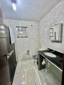 a bathroom with a sink and a toilet at Caiçara's house in Praia de Araçatiba +41 photos