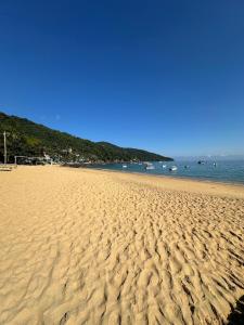 a sandy beach with a view of the ocean at Caiçara's house in Praia de Araçatiba