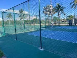 a fence on a tennis court with palm trees at Amazing Sunsets and dolphin sightings! in Fort Myers