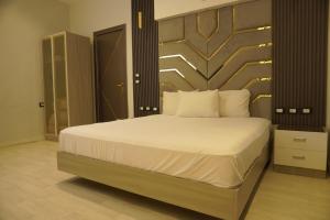 a bedroom with a large bed with a wooden headboard at Midtown Studio near Tahrir in Cairo