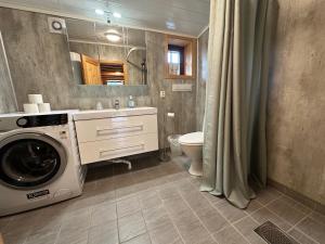 a bathroom with a washing machine and a sink at Bjorliheimen Fjellhotell-Hytte 11 & 12 in Bjorli
