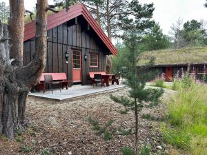 a cabin with a table and chairs in front of it at Bjorliheimen Fjellhotell-Hytte 11 & 12 in Bjorli