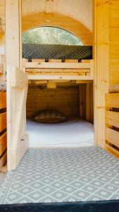 a wooden cabin with a bed in the middle at Schlaffass Natursee-Chalet mit Sanitärfass in Twist