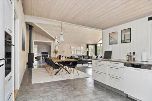 una cucina e un soggiorno con tavolo e sedie di BV259-Blavand-Almosetoften-17 a Blåvand