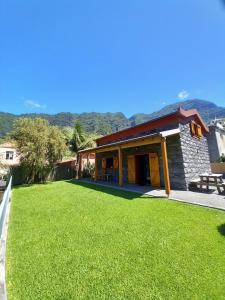 ein Haus mit einem grünen Rasen davor in der Unterkunft Refúgio do Limoeiro in São Vicente