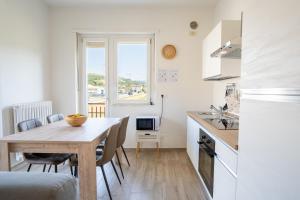 a kitchen and dining room with a wooden table in a kitchen at Private Parking, with Hill View in Alba +15 photos