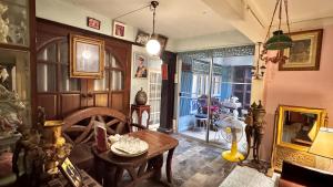 een woonkamer met een tafel en een kamer met een open haard bij Café de Baan Raow in Bangkok