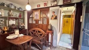 een eetkamer met een tafel en een gele deur bij Café de Baan Raow in Bangkok