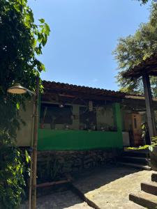 een huis met een groene muur aan de zijkant bij Quarto Golfinhos - Masculino in Pipa