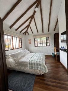 a bedroom with a large bed in a room with wooden floors at Blau Hotel&Café in Sopo