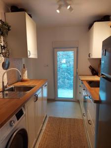a kitchen with white cabinets and a door with a window at Villa Arboreta in Tuhelj