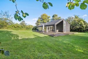 a house with a black roof on a grass field at 873-Melby-Bygtoften-3 in Melby