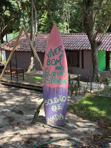 皮帕Camping do Jacaré的草地上放着一块写着字的冲浪板