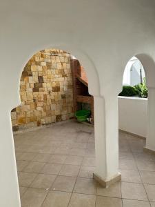 a room with a stone wall and two arches at Part Luxury in Cabo Negro