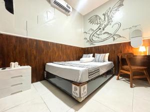a bedroom with a bed with a dragon stencil on the wall at Semarang CoStay in Alastuwo