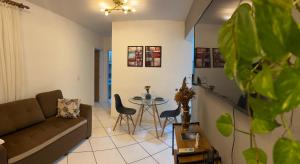 a living room with a couch and a table at Apartamento sofisticado com piscina e vista privativa in Ilhéus