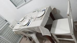 a white table and a chair with a white table cloth at Dptos Salim in San Fernando del Valle de Catamarca +7 photos