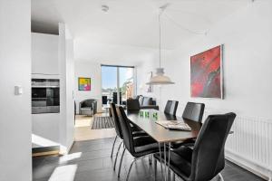 a dining room with a table and black chairs at 0274-Romo-Nordre-Havnevej-42 in Havneby