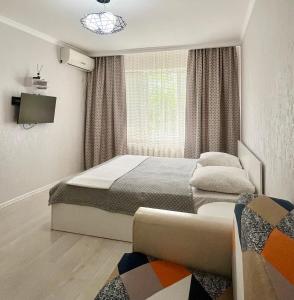 a bedroom with two beds and a window at Уютная квартира в 4 мкр Авангарда in Atyraū