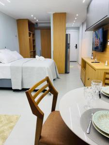 a room with a bed and a table and a kitchen at Art Studio Carimbamba, Jóia Rara! in Salvador +29 photos